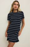 Woman wearing a navy and white striped dress against a plain background