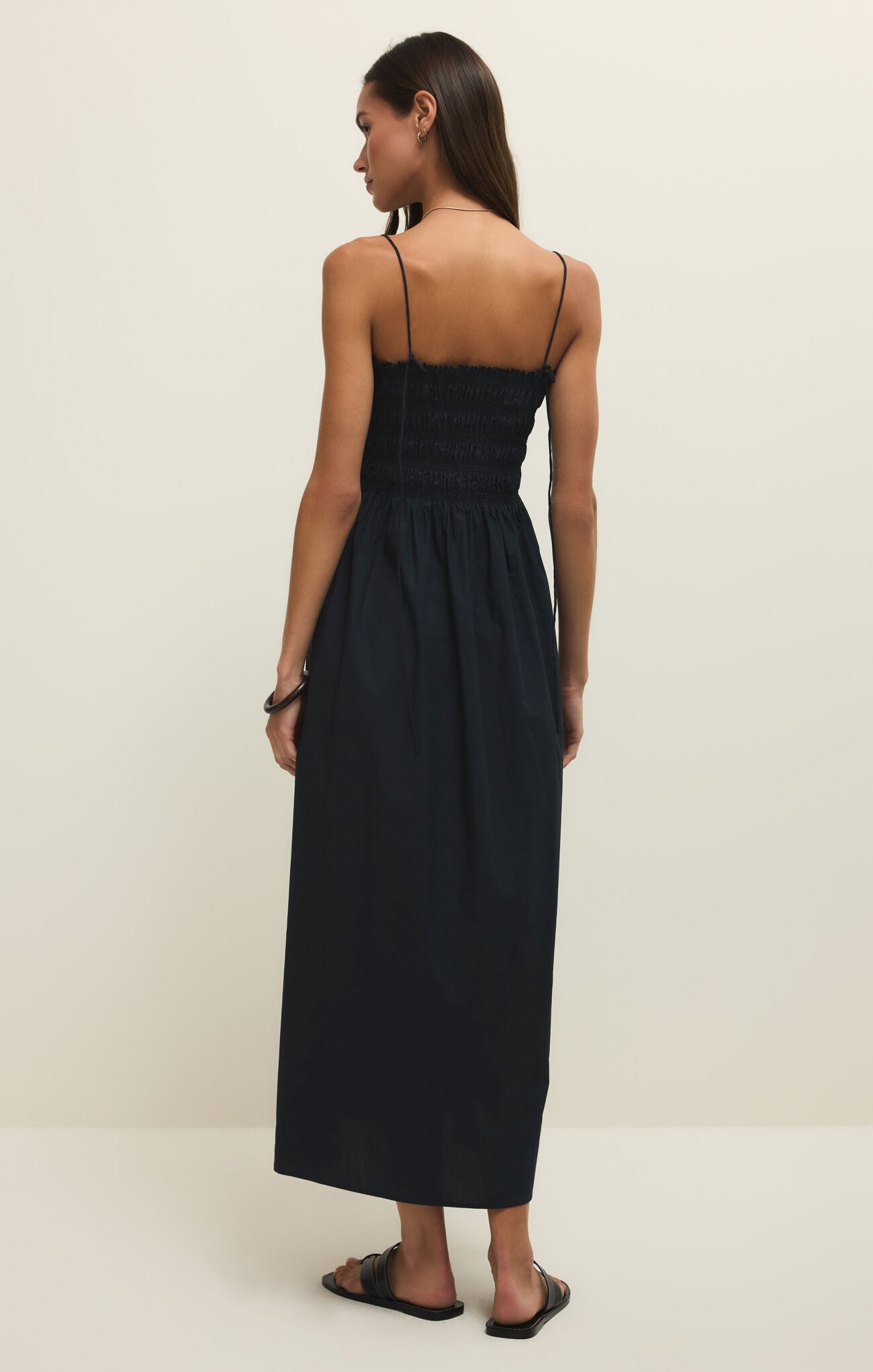 Woman wearing a black dress on a plain background