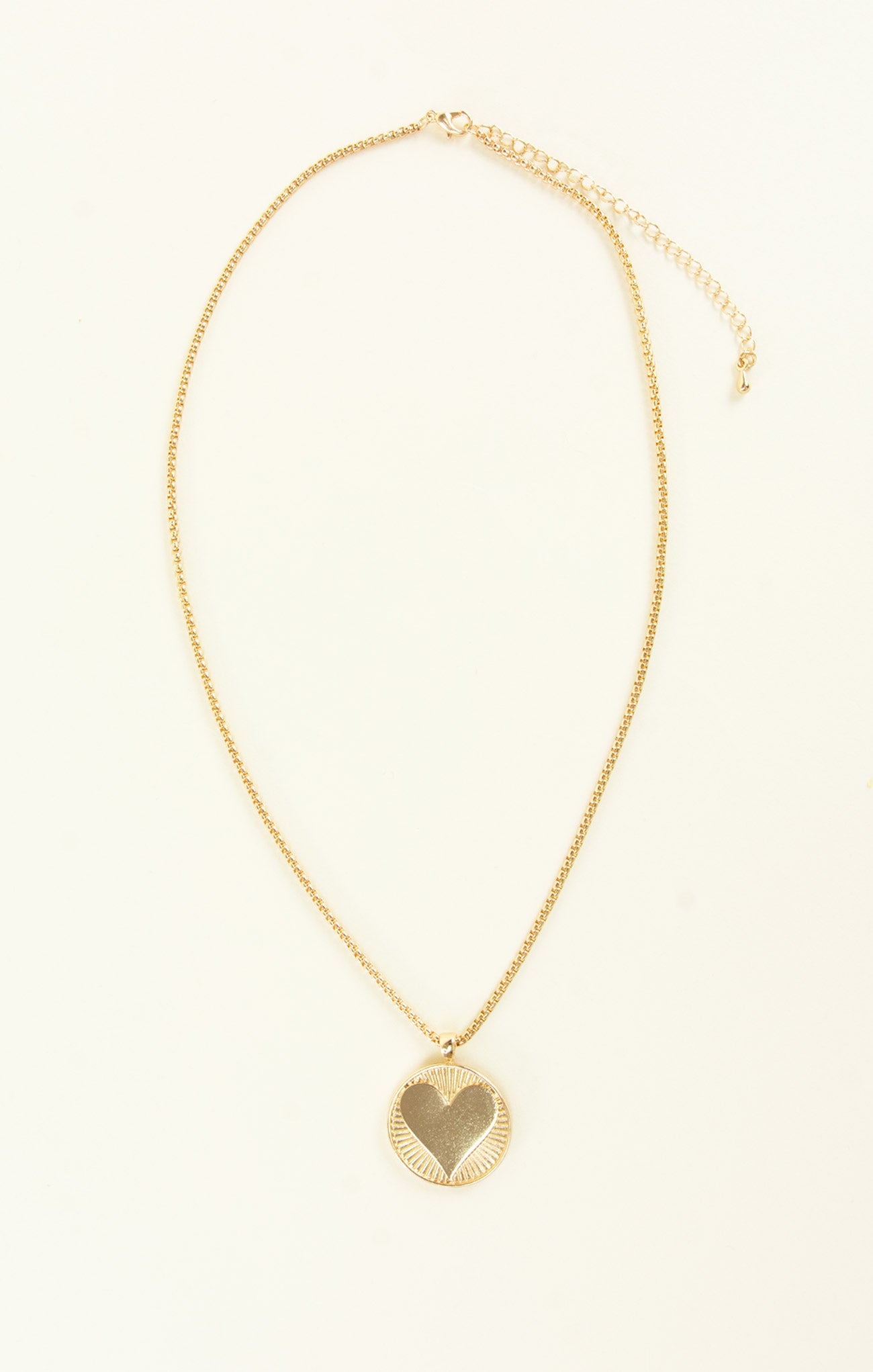 Gold necklace with a heart pendant on a white background
