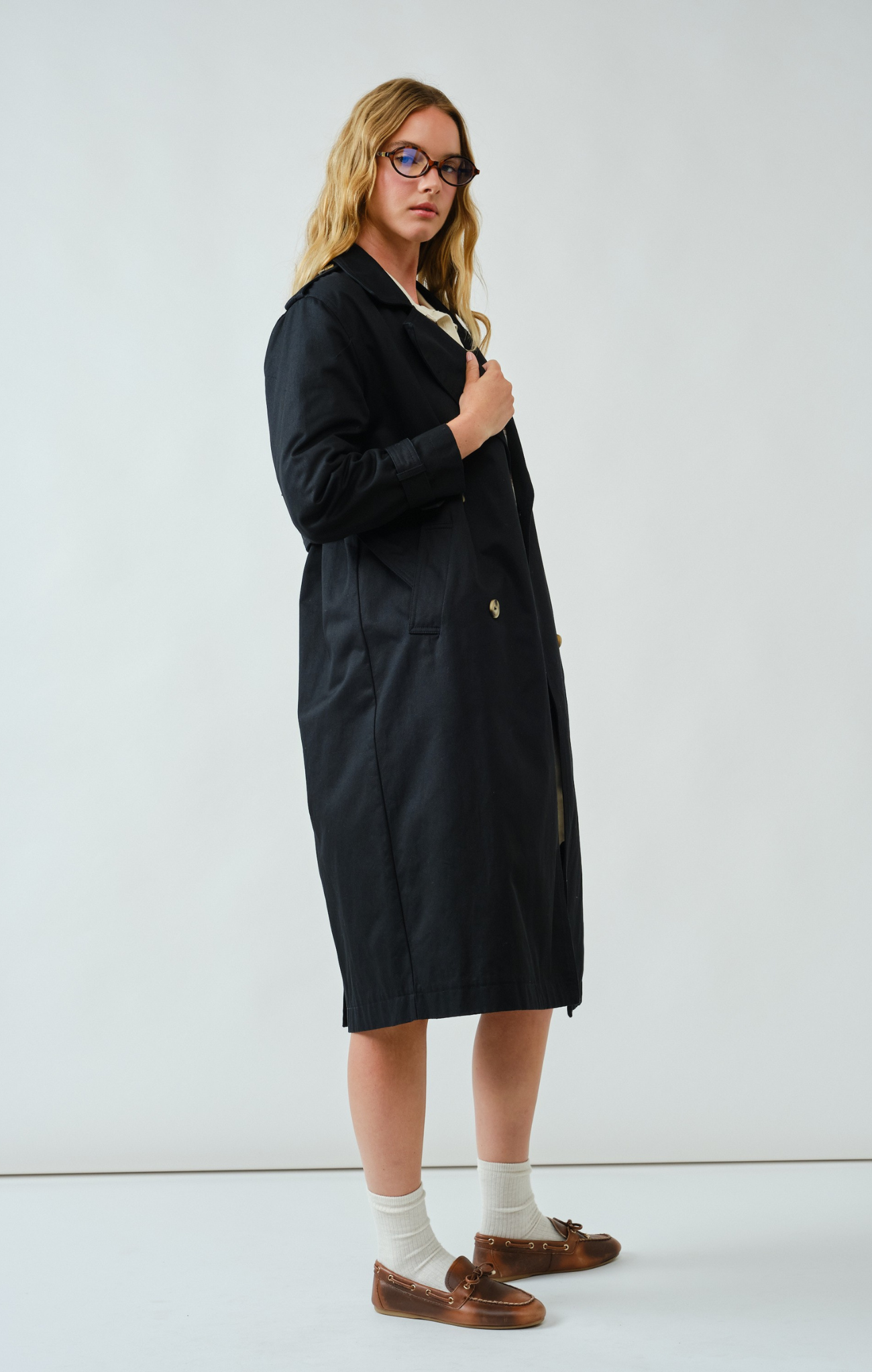 Person wearing a black coat on a white background