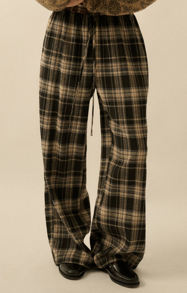 Plaid pants worn by a person on a beige background