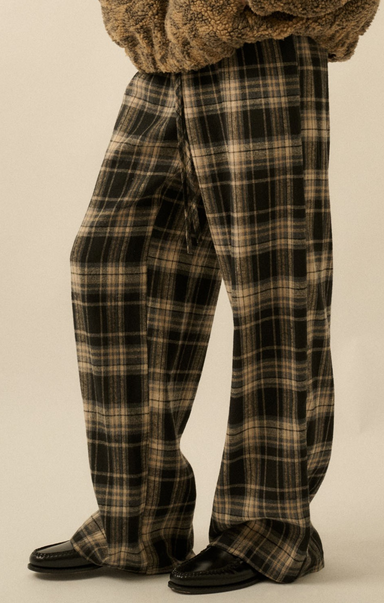 Plaid pants worn by a person on a beige background