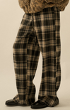 Plaid pants worn by a person on a beige background