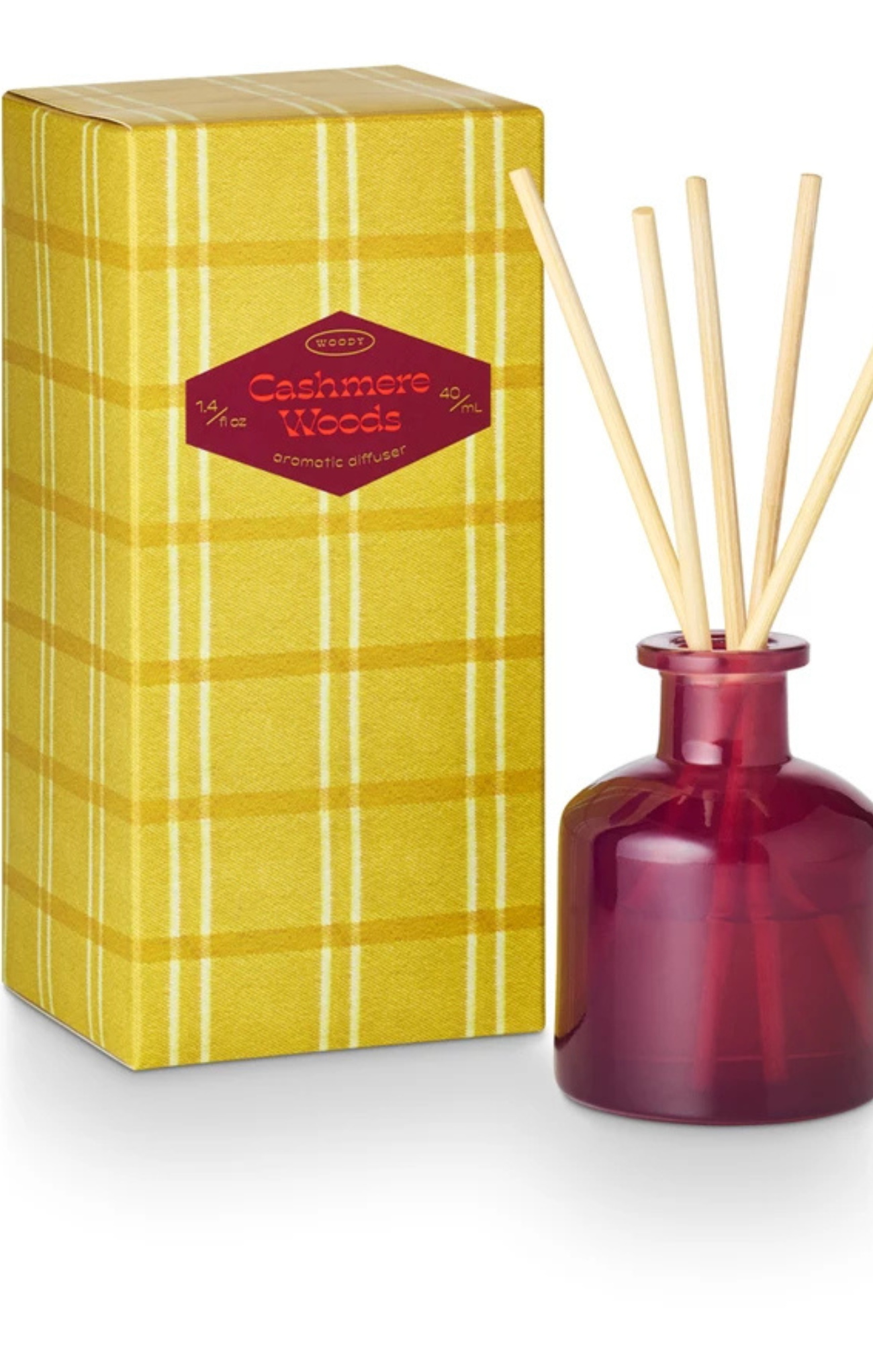 Red diffuser bottle with wooden sticks and yellow plaid box labeled 'Cashmere Woods' on a white background