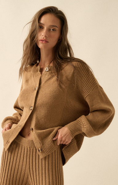 Woman wearing a brown knit cardigan and skirt on a beige background