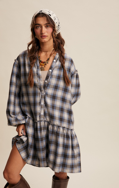 Woman wearing a plaid dress with a headscarf on a beige background