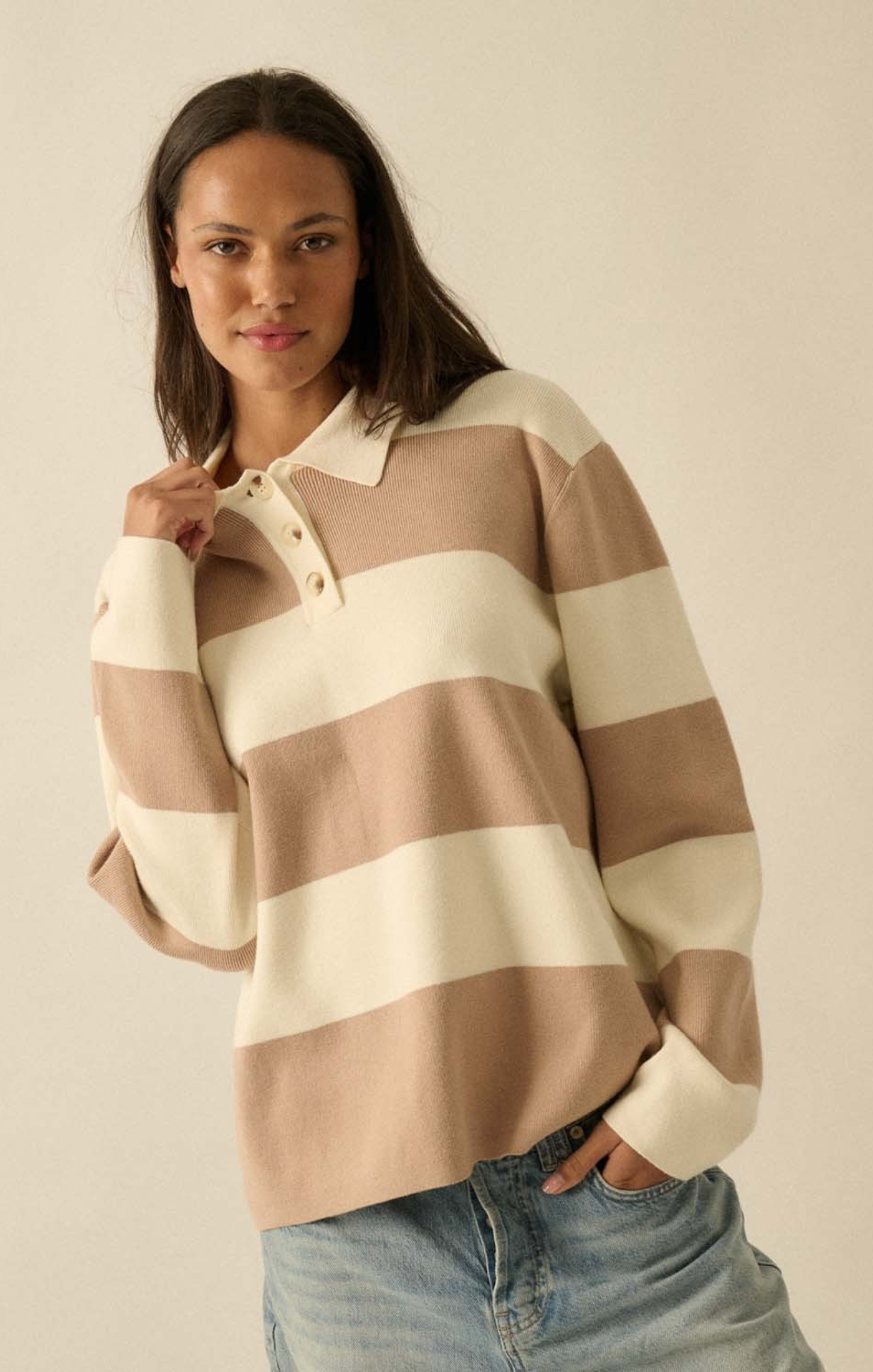 Woman wearing a striped sweater with a plain background