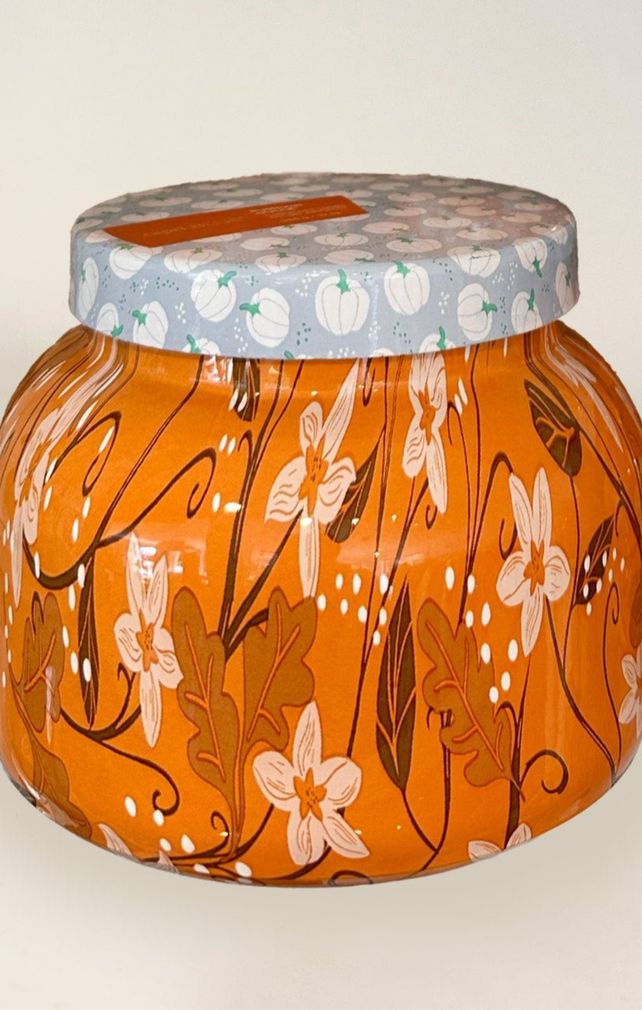 Decorative jar with floral design and patterned lid on a white background