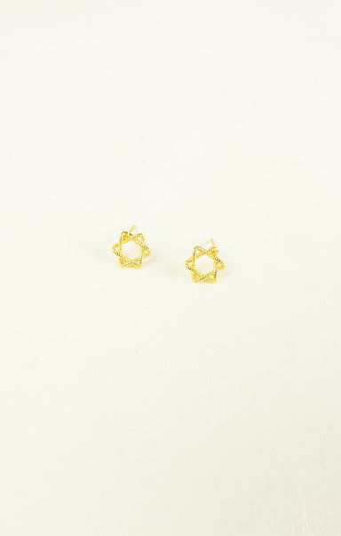 Gold star-shaped earrings on a light beige background