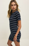 Woman wearing a navy and white striped dress against a plain background