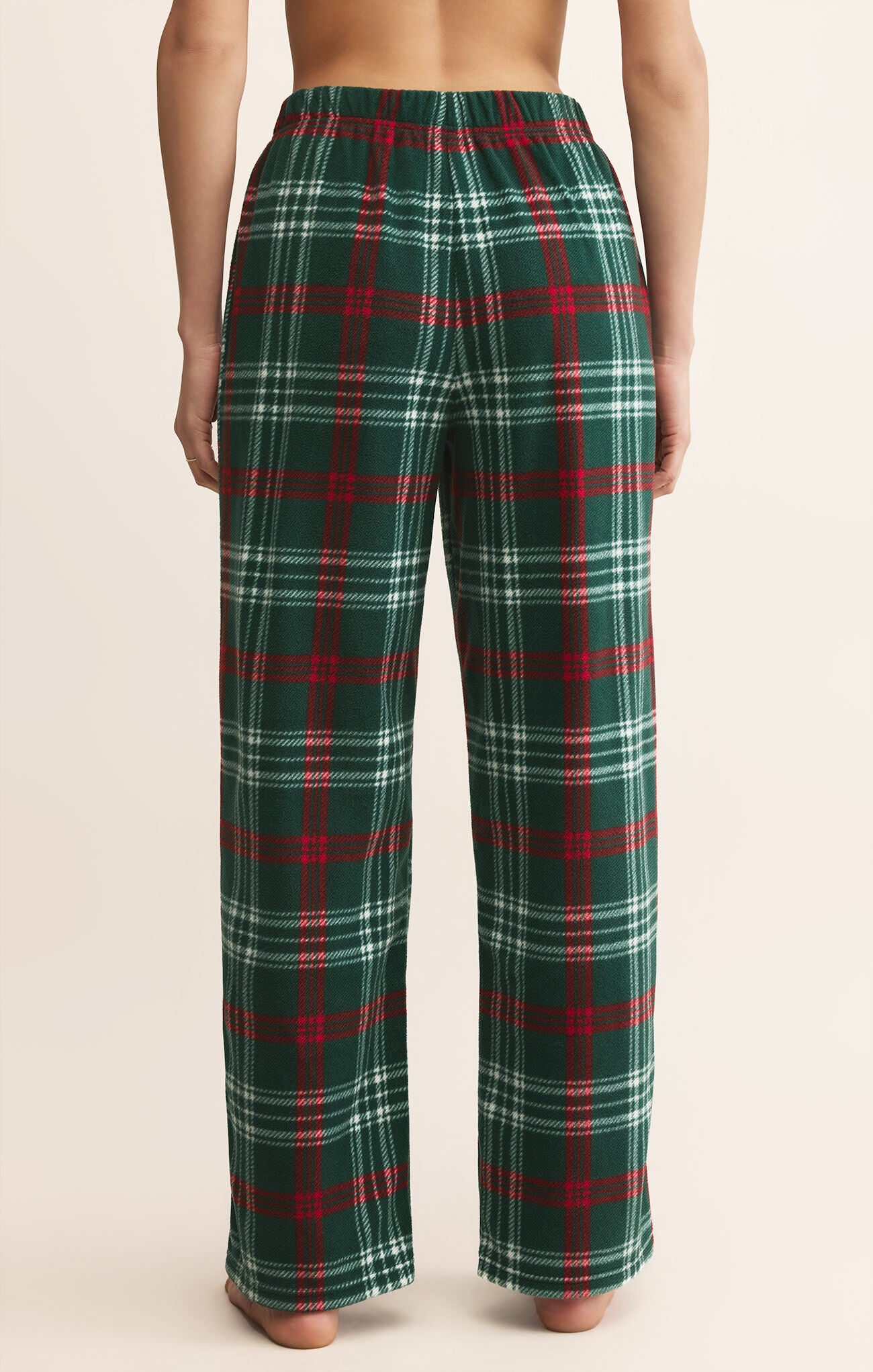 Green and red plaid pants worn by a person on a beige background
