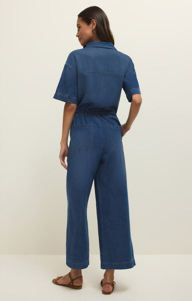 Woman wearing a blue jumpsuit on a white background