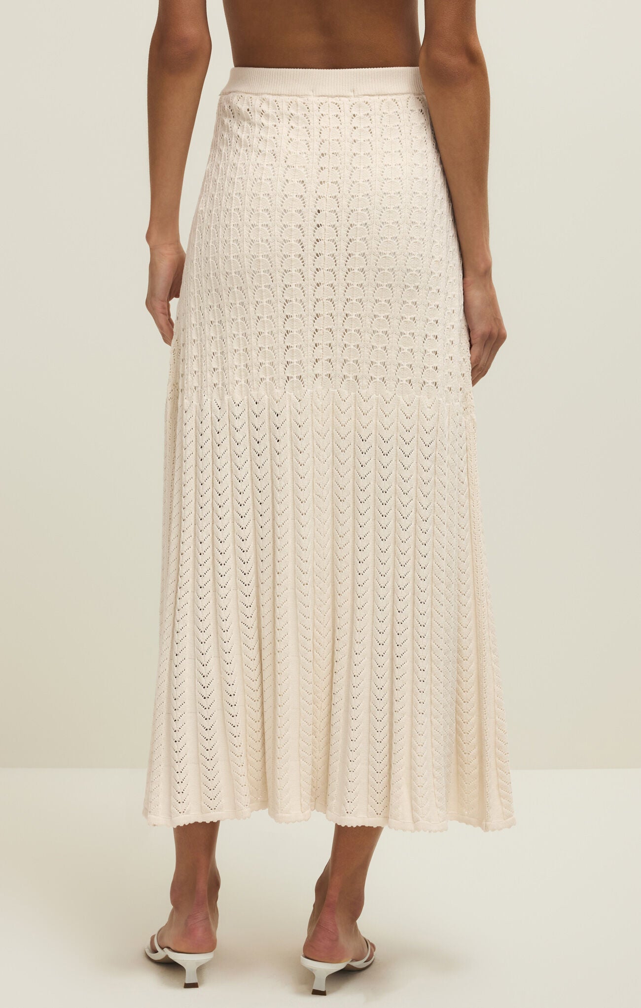 Beige crochet skirt worn by a person on a white background