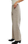 A person wearing light beige wide-leg pants with black heeled boots and a white top, shown from the waist down against a plain white background.