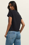 Woman wearing a black t-shirt and blue jeans on a plain background