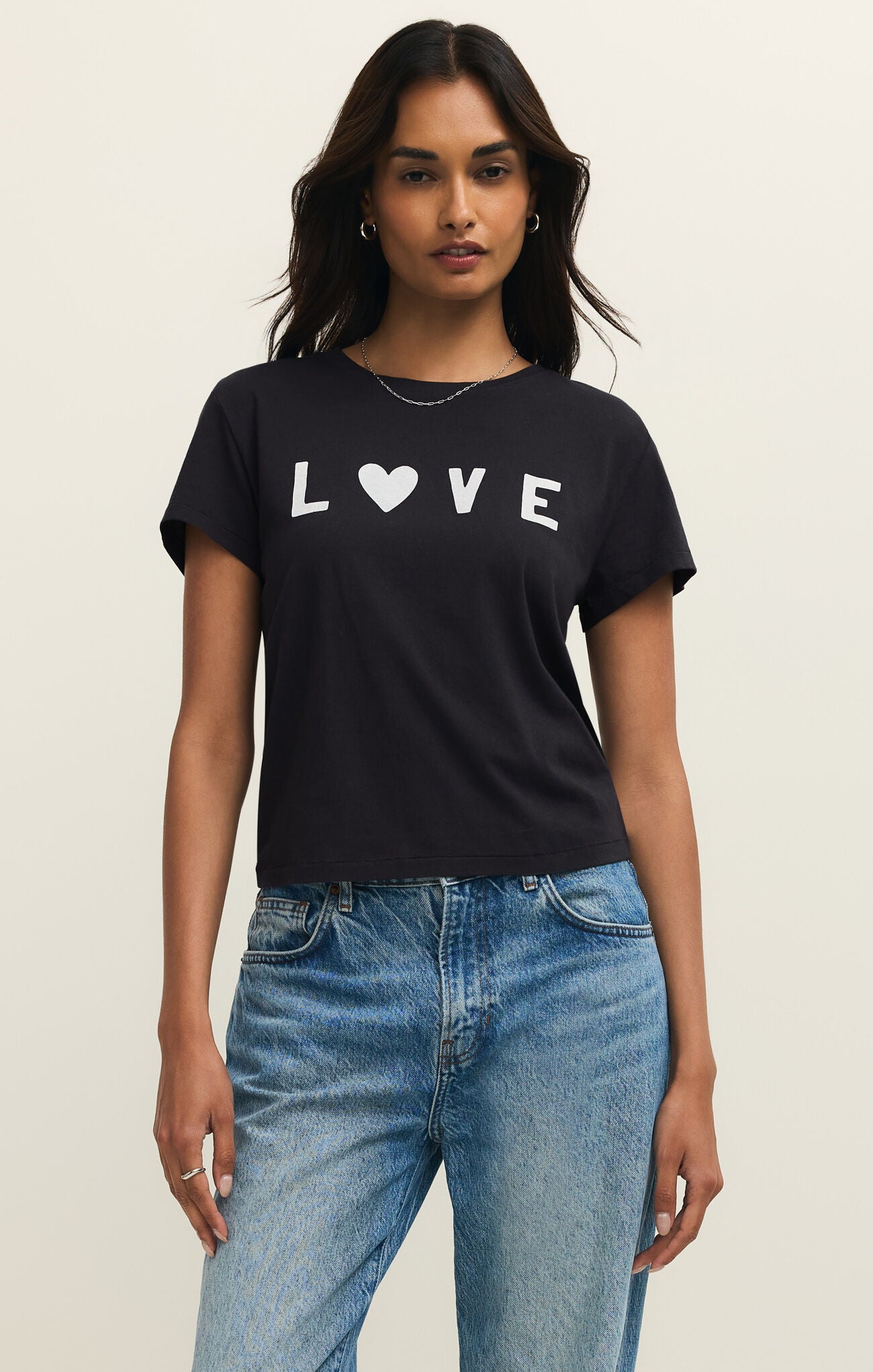 Woman wearing a black t-shirt with 'LOVE' printed on it, standing against a plain background.