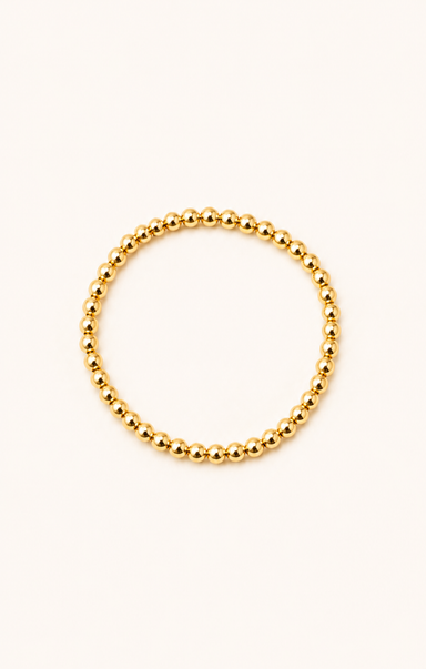 women wearing a gold bracelet at the beach
