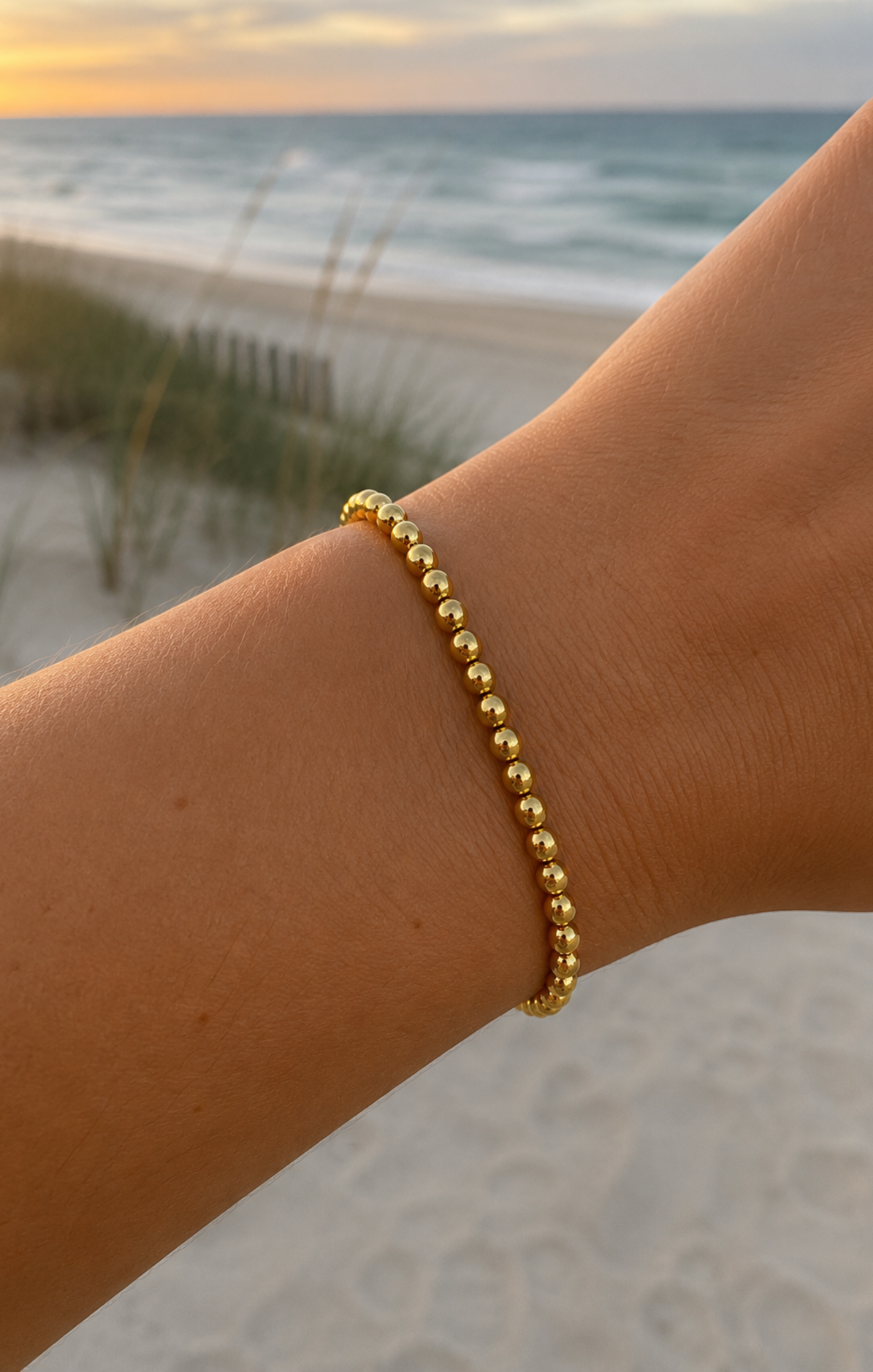 women wearing a gold bracelet at the beach