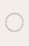 Silver beaded bracelet on a wrist with a beach background