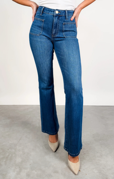 Person wearing blue jeans with a plain background