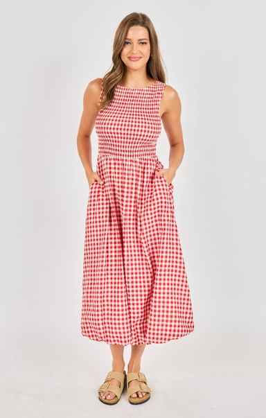 Woman wearing a red and white checkered dress on a plain background