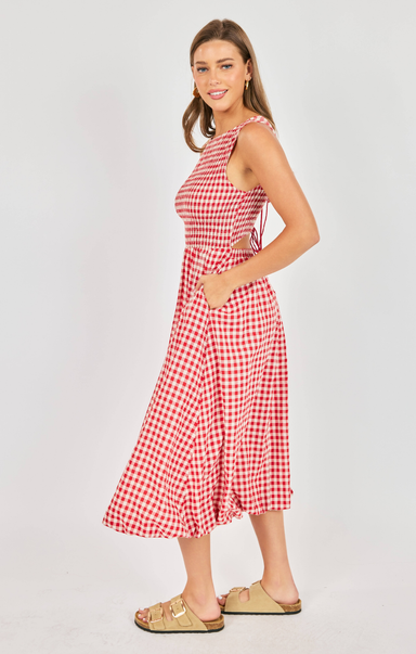Woman wearing a red and white checkered dress on a plain background