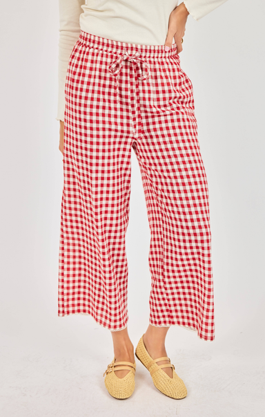 Red and white checkered pants worn by a person on a light gray background