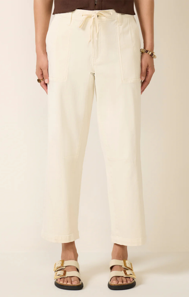 Person wearing beige pants with a plain background