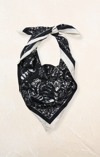 Black floral patterned scarf with white border on a beige background