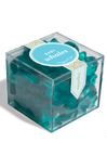 Teal whale-shaped bath bombs in a clear box with a label on a white background