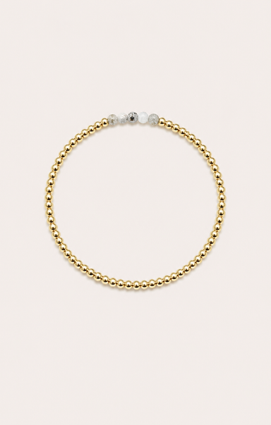 gold bracelet on neutral background
