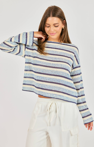 woman wearing striped blue shirt with white pants on white background