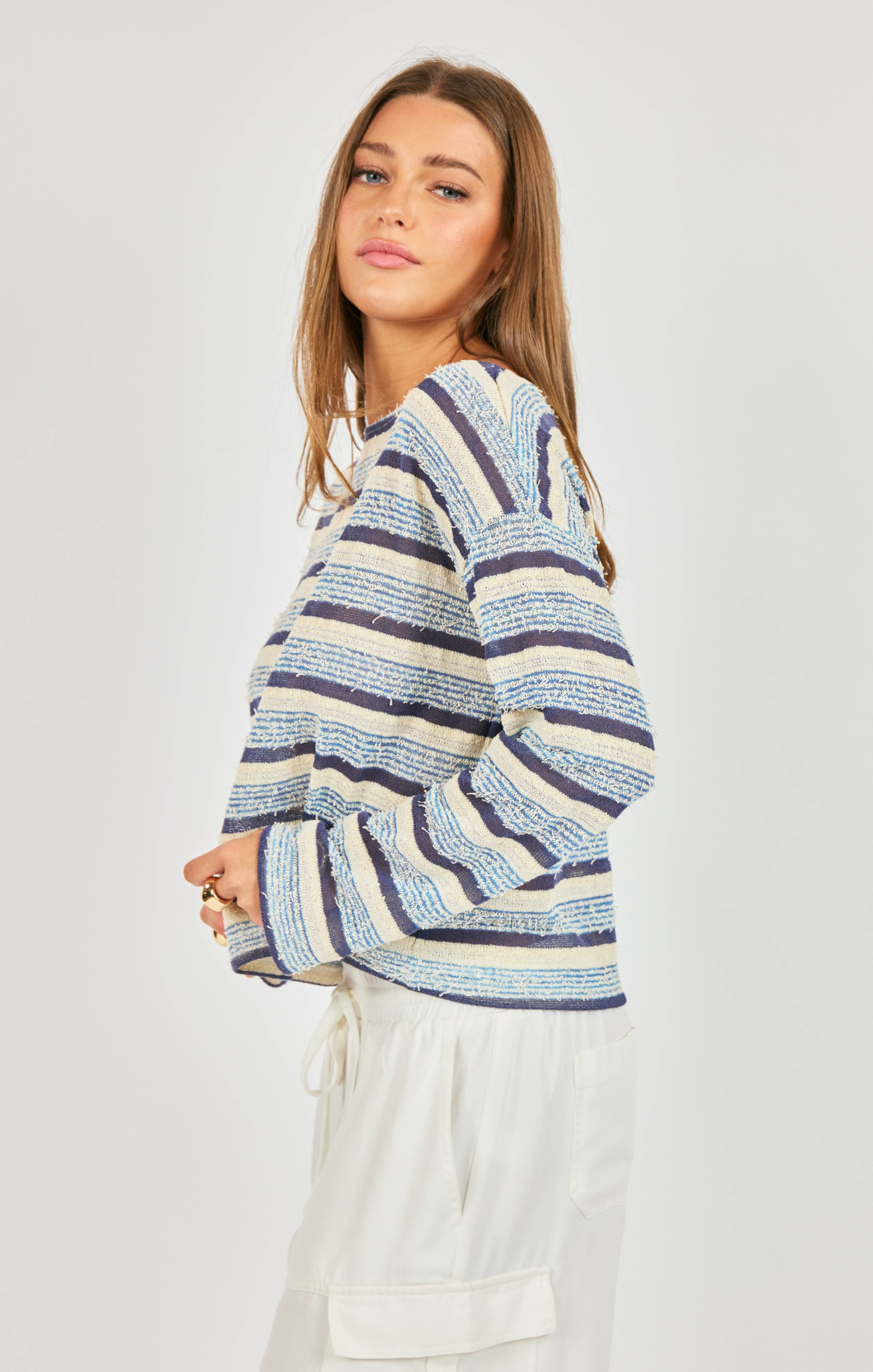 woman wearing striped blue shirt with white pants on white background