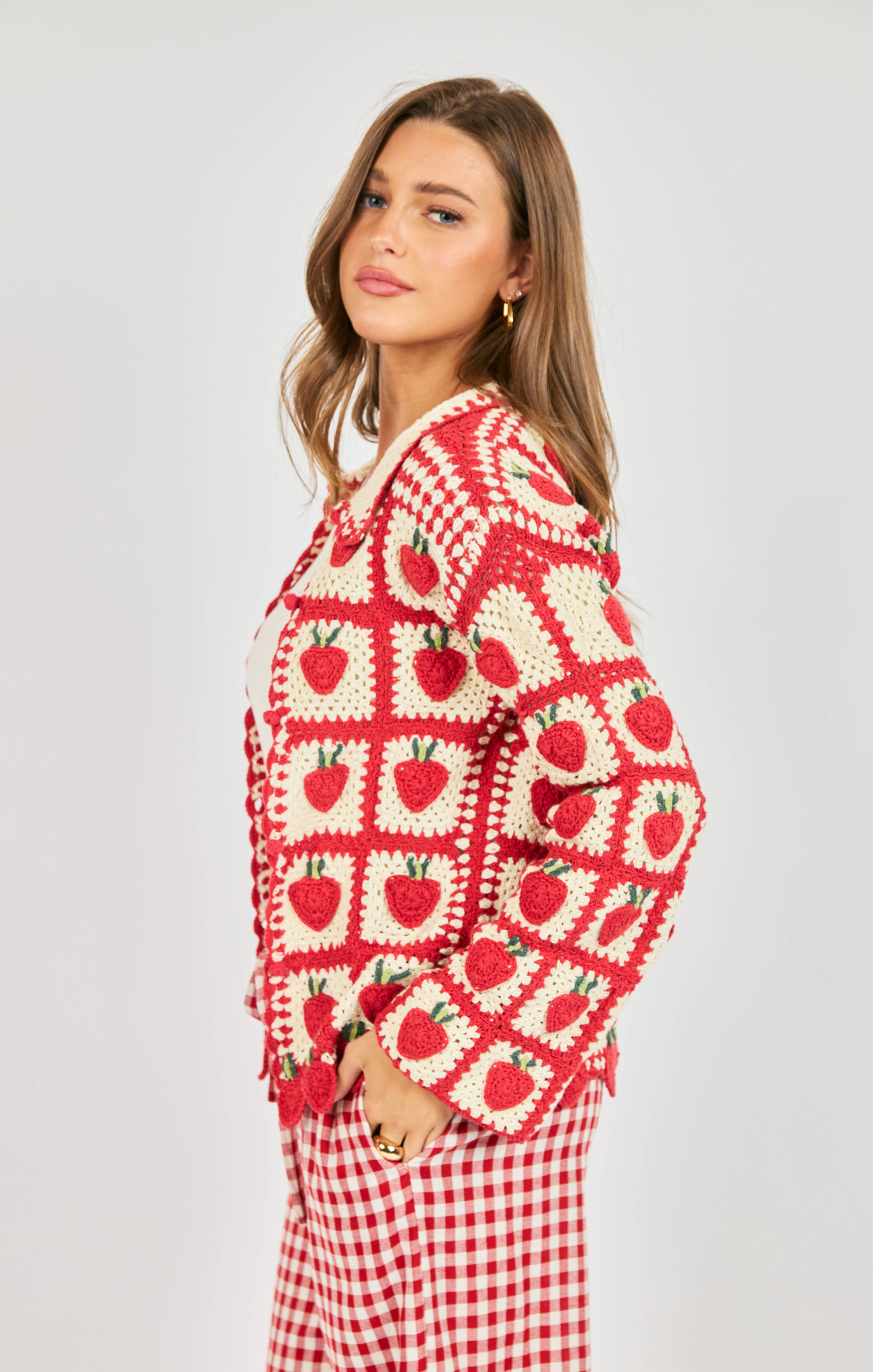 Woman wearing a red and white patterned sweater with a plain background