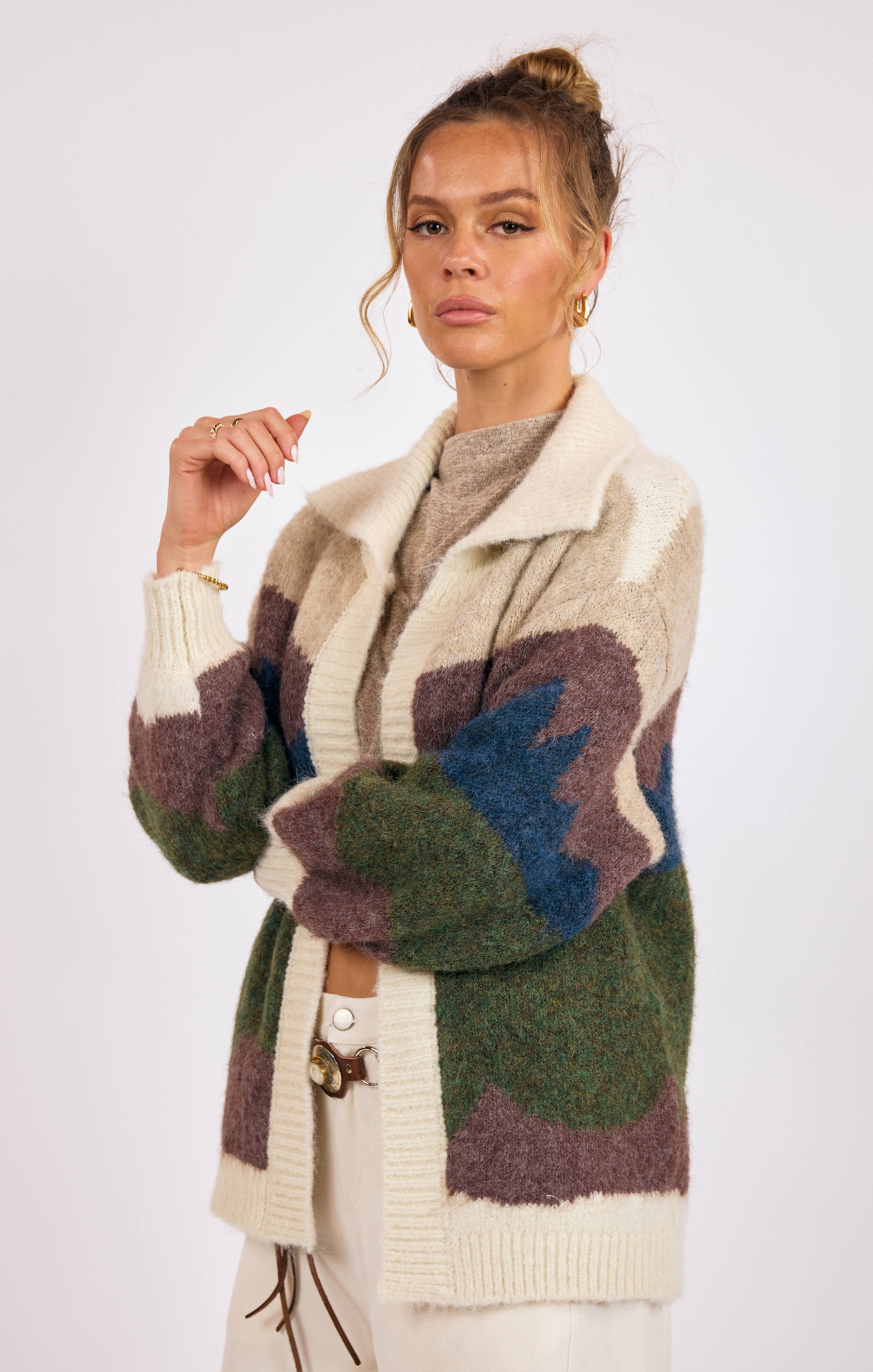 Woman wearing a patterned cardigan on a white background