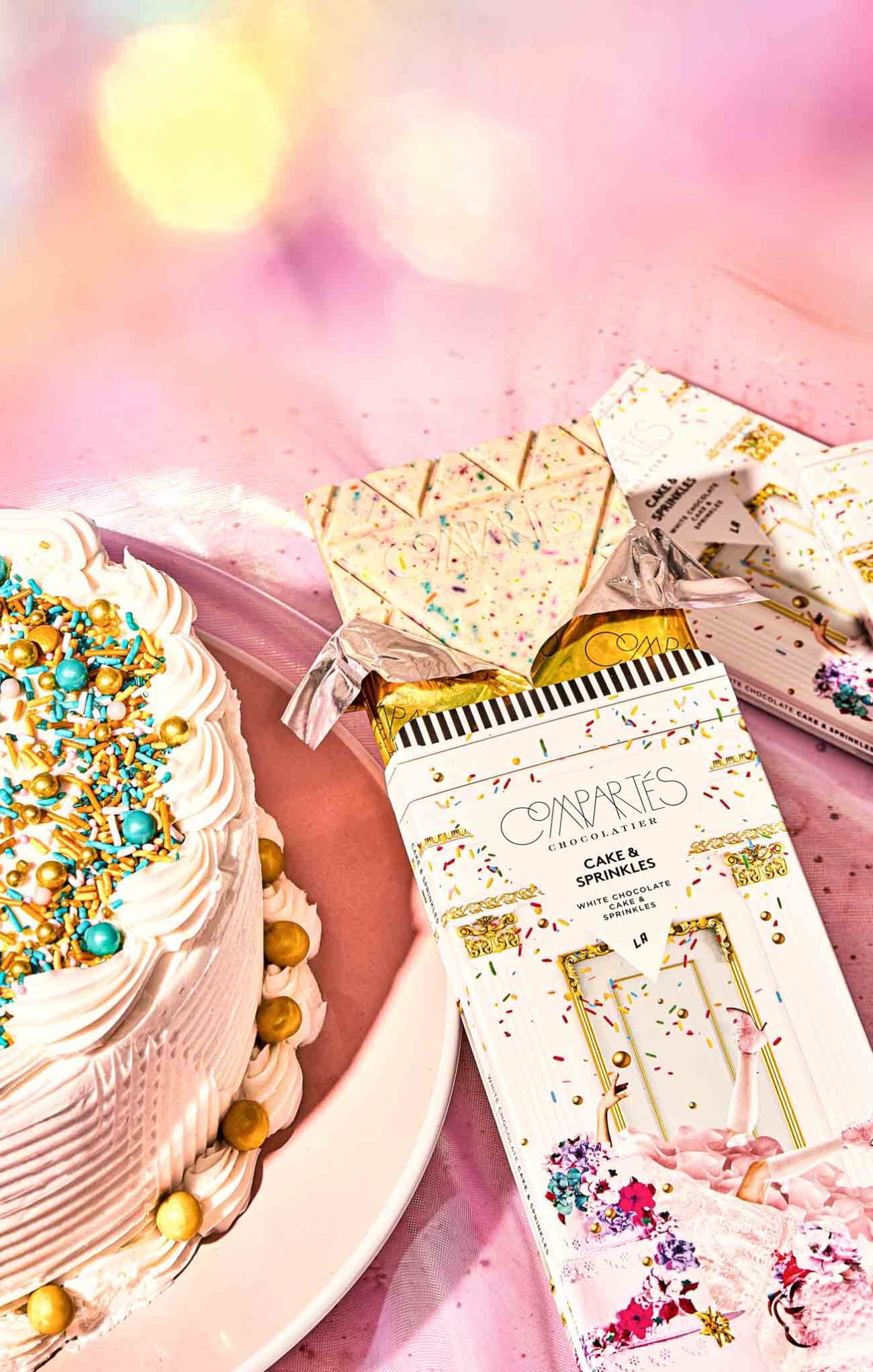 Cakes and decorative boxes on a pink surface with a blurred background