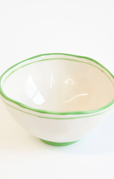 White bowl with green rim on a white background