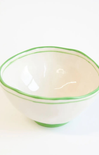 White bowl with green rim on a white background