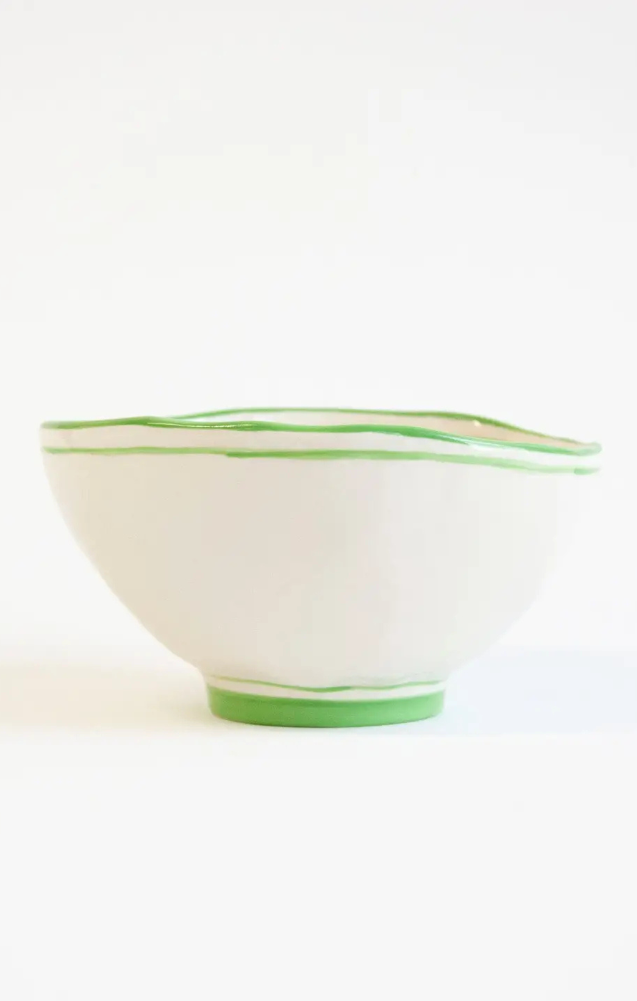 White bowl with green rim on a white background