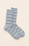 Gray striped sock on a white surface with a book in the background