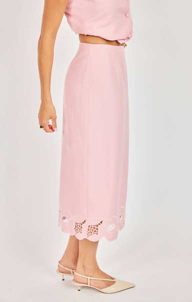 Pink outfit with lace details on a plain background
