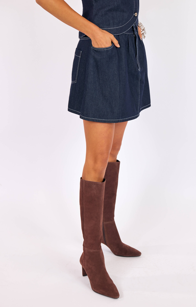 woman wearing blue skirt with knee high boots with white background