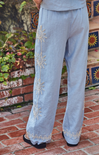 Light blue pants with sun designs on a brick ground.