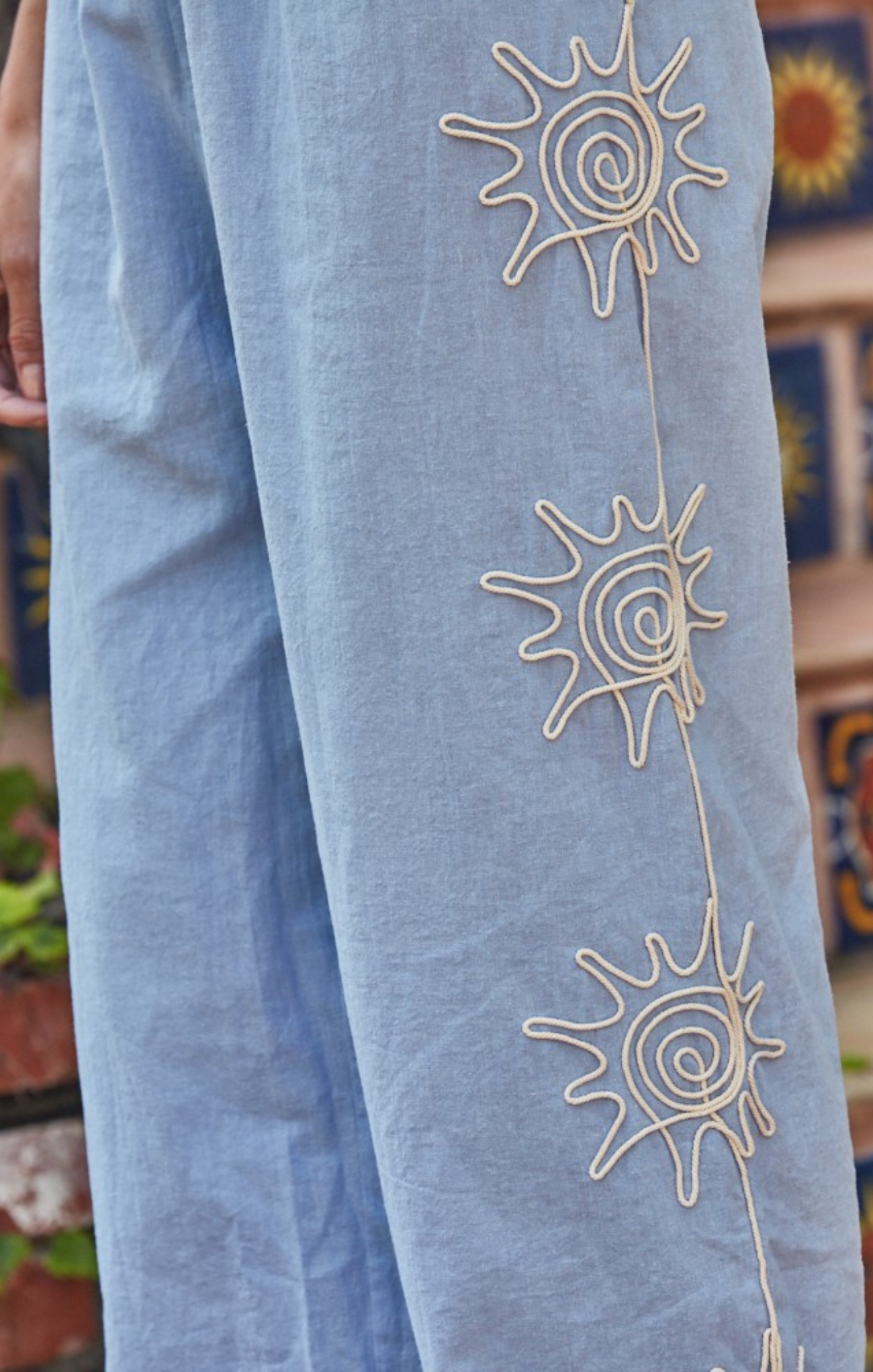 Light blue pants with sun designs on a blurred background