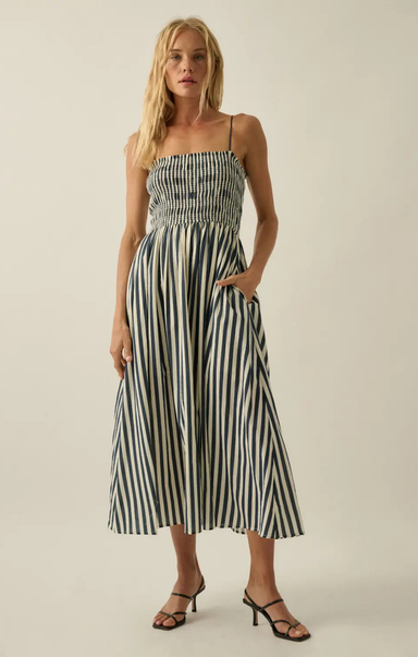 Woman wearing a black and white striped dress on a plain background