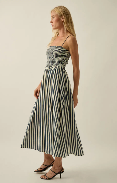 Woman wearing a black and white striped dress against a plain background