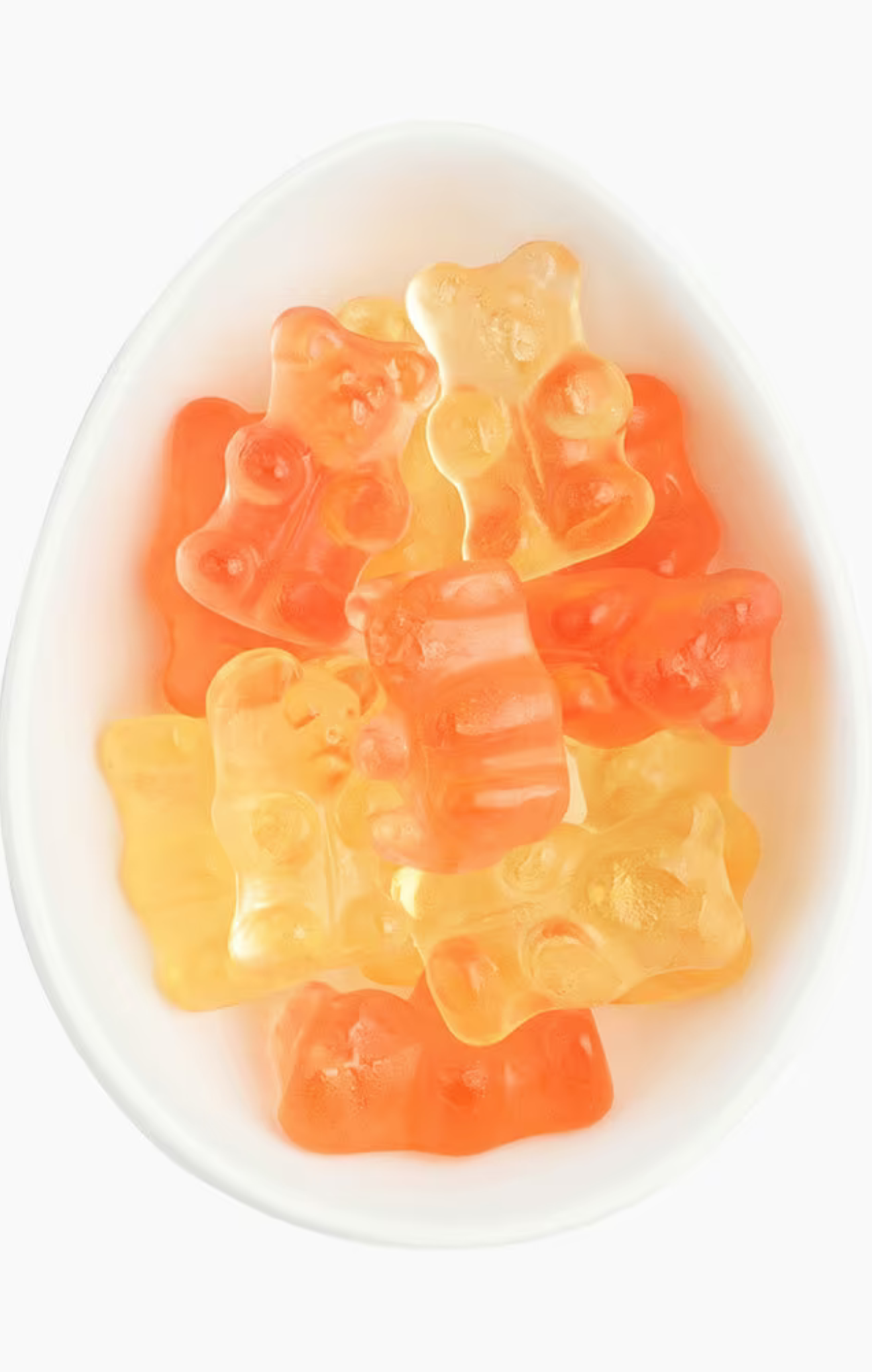 Gummy bears in orange and yellow on a white plate