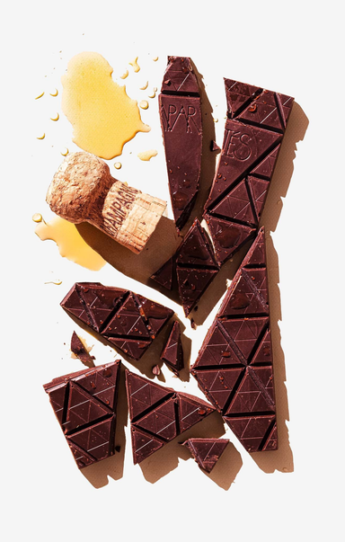 Broken chocolate bar with a cork and honey on a white background