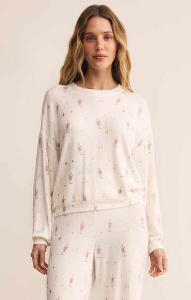 Woman wearing a white long-sleeve top and pants with a subtle pattern on a plain background