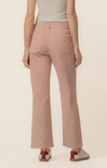 Person wearing pink ribbed pants on a beige background